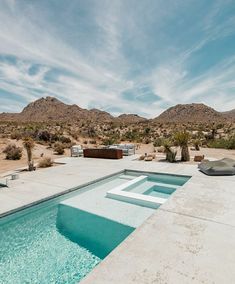 an empty swimming pool surrounded by mountains in the desert