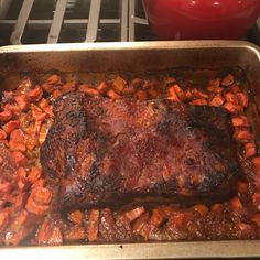 meat and carrots are cooking in the oven