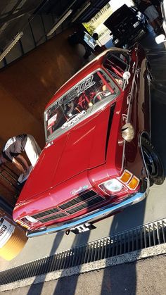 an old red car parked in a garage