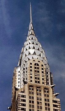 a very tall building with a clock on it's side in front of a blue sky