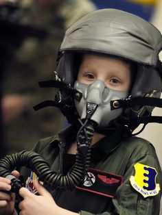 a young boy wearing an air force pilot's helmet