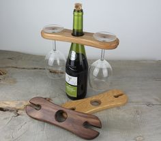 two wine glasses, a bottle opener and a wooden board with corks are sitting next to each other