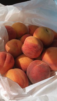 a bunch of peaches sitting in a white bag