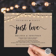 someone holding up a wedding card with string lights in the background that reads, nothing fancy just love