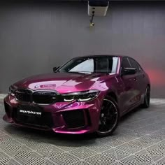 a purple car parked in front of a wall