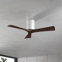 a ceiling fan that is mounted to the ceiling in a room with white walls and windows