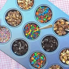 a muffin tin filled with lots of different types of toppings and sprinkles