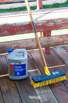 a mop and broom sitting on top of a wooden deck