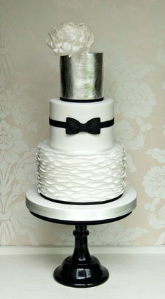 a white and black wedding cake with flowers on top