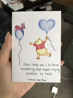 someone is holding up a card with winnie the pooh on it and some balloons