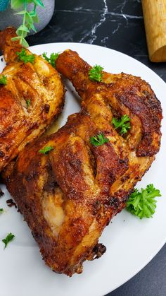 two pieces of chicken on a plate with parsley