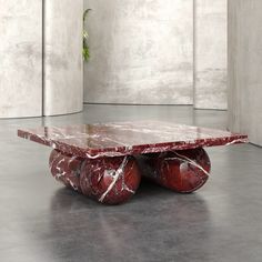 a marble coffee table with two red balls on it and a plant in the middle