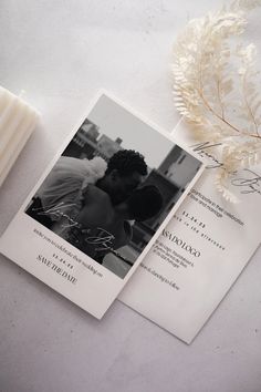 a couple kissing on their wedding day next to some flowers and a candle that is laying on the ground