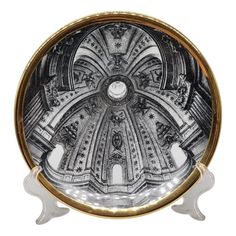 a black and white plate with an ornate design on the front, in gold trim