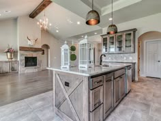 a large kitchen with an island in the middle and lots of cabinets on either side