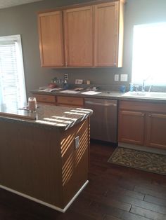 a kitchen with wooden cabinets and an island in front of the stove top oven, sink and dishwasher