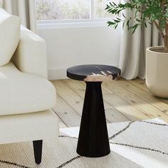 a living room with white furniture and a potted plant on the floor next to it