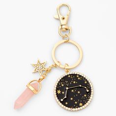 a keychain with a star and moon design on the front, along with a pink beaded charm