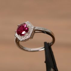 It is a lab ruby ring. The main stone is 7mm round cut, weight about 1.65 carats. The basic metal is sterling silver and plated with rhodium. To change the metal to a solid gold (white/rose) or platinum is also available, please ask for a quotation if you want. You can also go to my shop Home for more elegant rings: https://www.etsy.com/shop/godjewelry?ref=hdr_shop_menu Ruby is the birthstone of July, it will be a great gift for your lover! More ruby rings: https://www.etsy.com/shop/godjewelry?r Classic Silver Ruby Ring With Halo Design, Octagon Ruby Ring In Fine Jewelry Style, Octagon Ruby Ring Fine Jewelry, Ruby Ring With Halo Design For Promise, Round Cut, Silver Sterling Ruby Ring With Halo Design, Silver Ruby Ring With Halo Design In Cubic Zirconia, Ruby Gemstone Halo Ring With Round Cut, Silver Ruby Ring With Halo Design In Sterling Silver, Fine Silver Ruby Ring With Halo Design