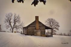 an old log cabin sits in the snow