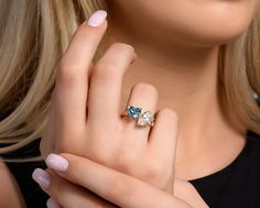 a close up of a person wearing a ring with an oval shaped diamond on it