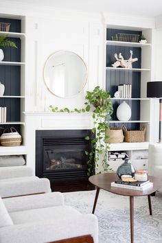 a living room filled with furniture and a fire place in front of a white fireplace