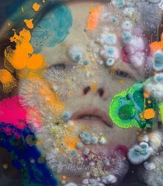 a child's face is surrounded by colorful bubbles and paint sprinkles