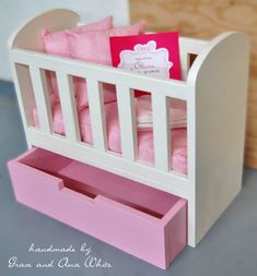 there is a toy crib with pink sheets in it