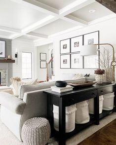 a living room filled with white furniture and pictures on the wall above the fire place