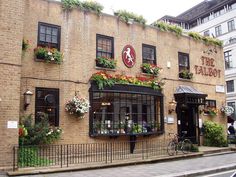 a brick building with flowers on the front and windows above it's doors, along with a bicycle parked outside