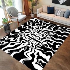 a black and white area rug with an abstract design on the floor in a living room