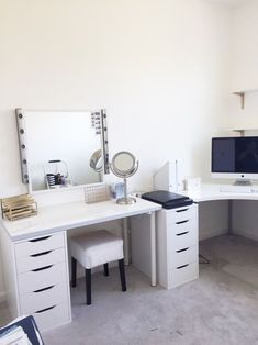 a white desk with two computer monitors on it