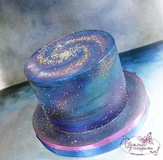 a blue and purple hat with gold glitters on it's top sitting on a table