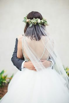 a bride and groom embracing each other under a veil