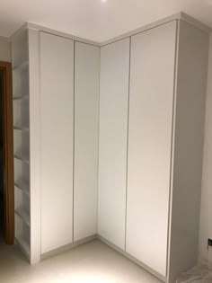 an empty room with white cupboards and shelves