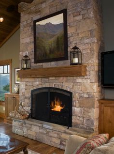 a living room with a stone fireplace and television