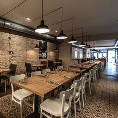 an empty restaurant with wooden tables and white chairs