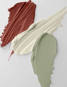 three different shades of paint next to each other on a white surface, one is green and the other is red