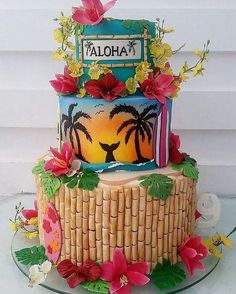 a three tiered cake decorated with flowers and palm trees