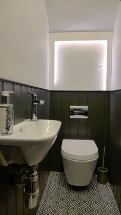 a white toilet sitting next to a sink in a bathroom under a skylight above it