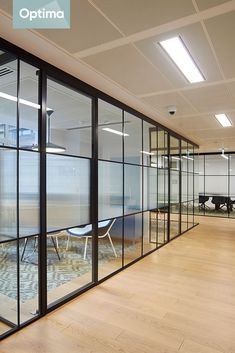 an office with glass walls and wooden floors