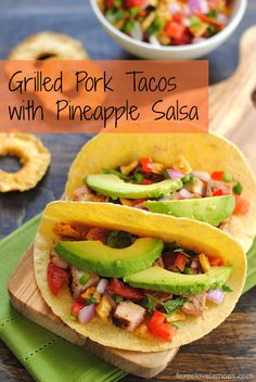 grilled pork tacos with pineapple salsa and avocado on a cutting board