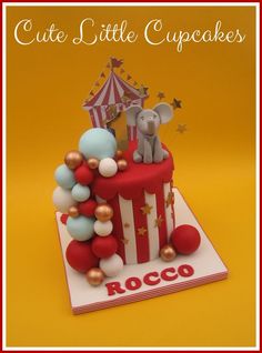 a circus themed birthday cake with balloons and an elephant on top that says, cute little cupcakes rocco