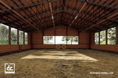 an empty barn with large windows in the center and dirt flooring on both sides