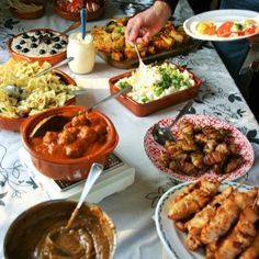 a table filled with lots of food and dipping sauces on top of it's plates