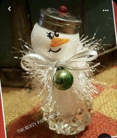 a glass jar with a snowman ornament in it