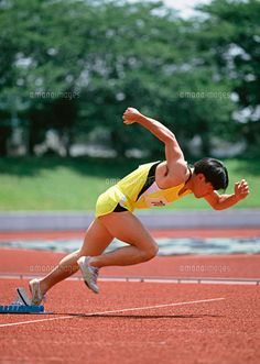 a woman in yellow and black running on a track