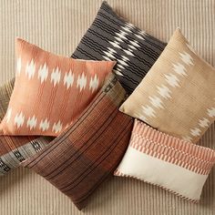 several pillows are arranged on a couch with different colors and patterns in the same pattern