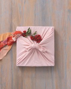 a present wrapped in pink paper with berries on it