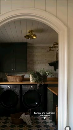 a washer and dryer are in the middle of a kitchen with black cabinets